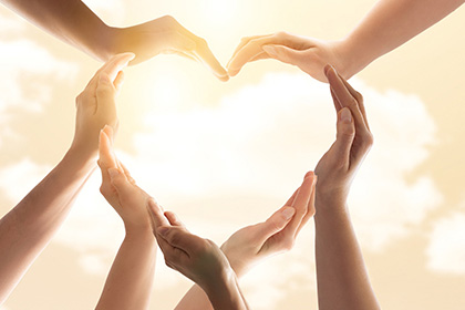 Symbol and shape of heart created from hands.