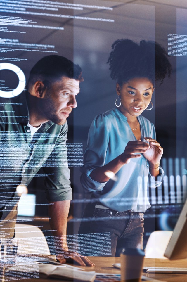 Shot of two programmers working together on a computer code at night