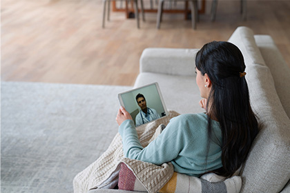 Virtual Care - A Lady taking online consultation appointment with Doctor on tablet